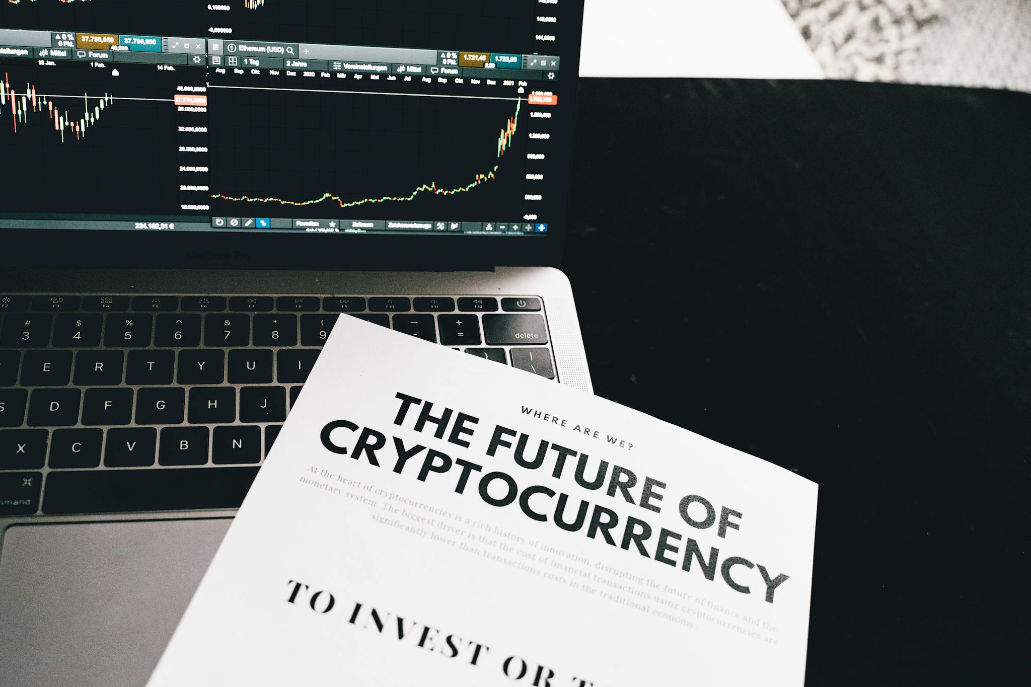 A detailed look at cryptocurrency market trends using a laptop and analytical document.