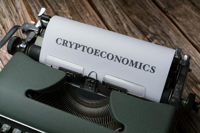 Cryptoeconomics typed on paper using vintage typewriter on wooden background.
